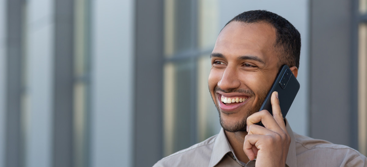 cheerful-and-smiling-african-man-using-smartphone