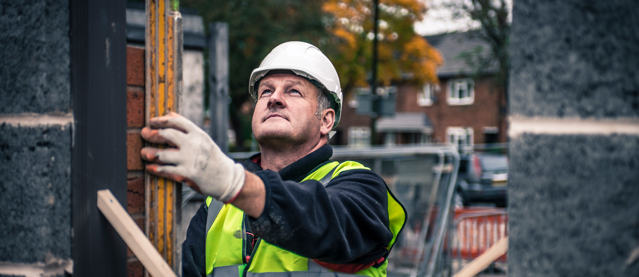 construction-worker-assessing-brick-wall-with-level