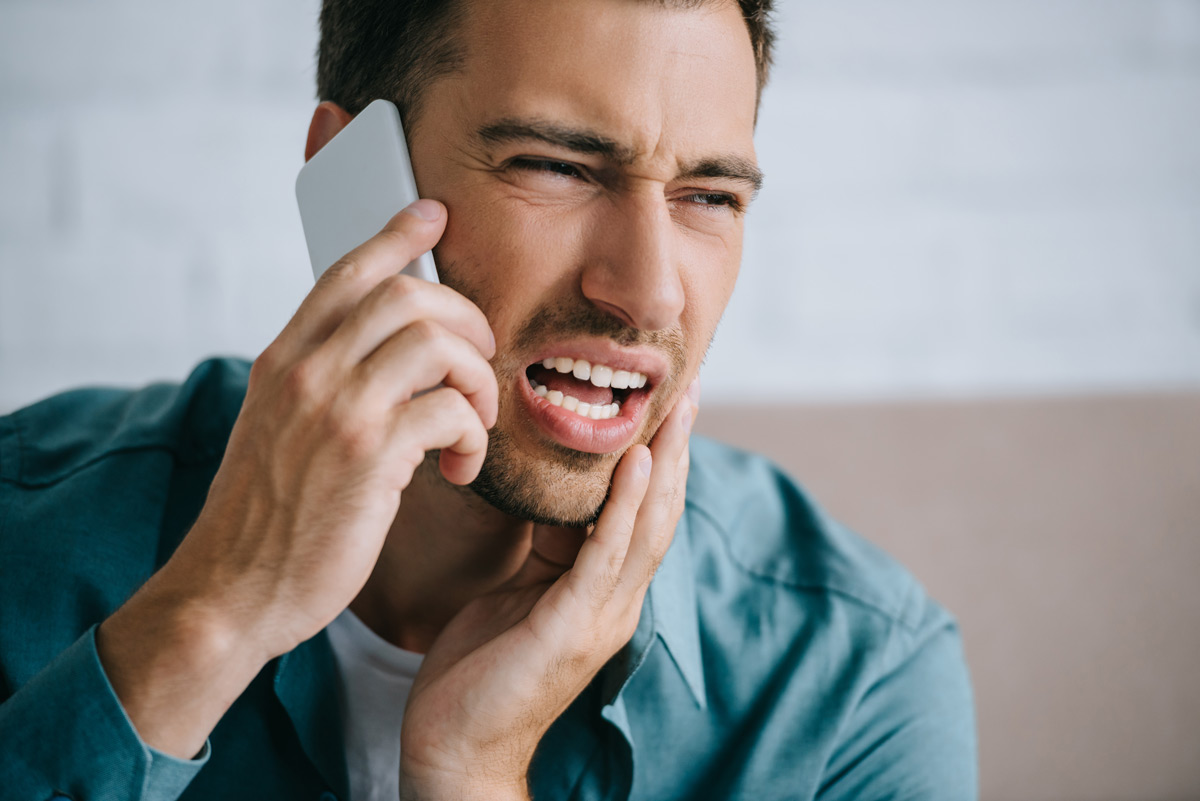 man-with-tooth-pain-talking-on-phone