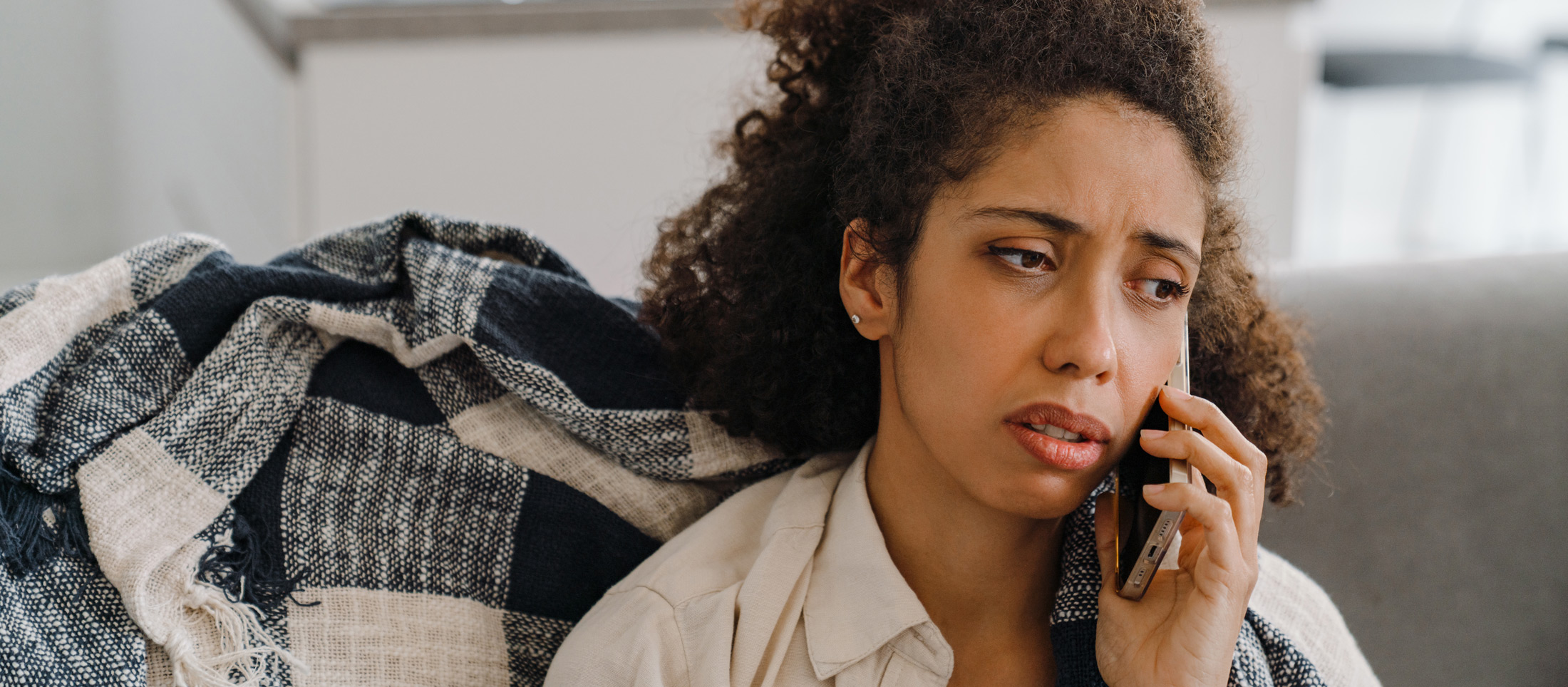 worried-woman-talking-on-the-phone-indoors